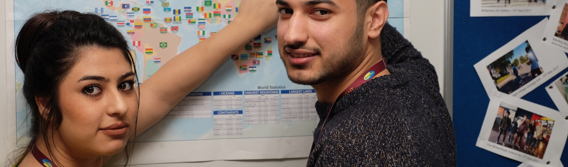 Two WMC ESOL students standing in front of map inside classroom