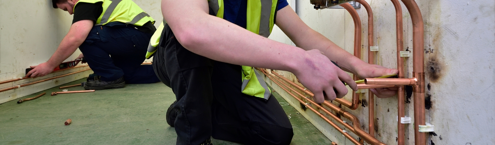 WMC Plumbing Studies Diploma student working on a wall