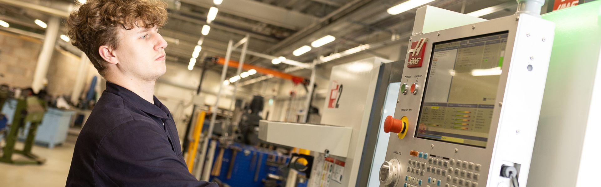  A male engineering student uses a machine in the workshop 