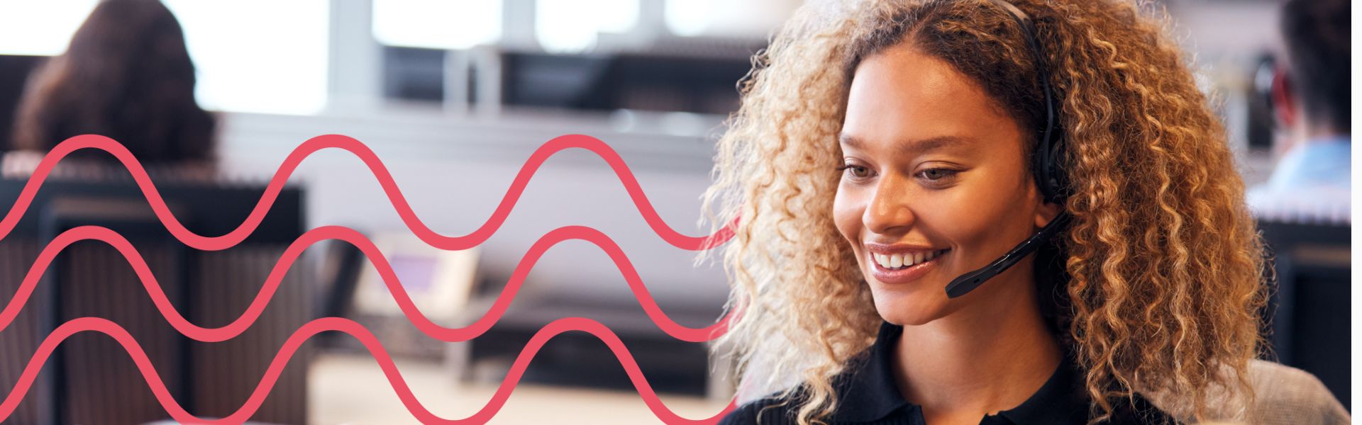 Woman working in an office environment. She is wearing a headset