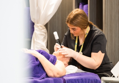 Female Hairdressing Beauty Therapy And Wellbeing Student Applying Makeup To Woman