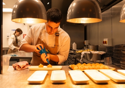 Wirral Met Hospitality and Catering student smiling, inside of training kitchen