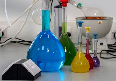 Female Part Time Science Student Wearing Labcoat Standing In A Lab