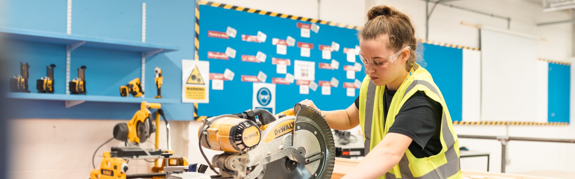 Carpetnry & Joinery student using saw inside workshop in Wirral Waters