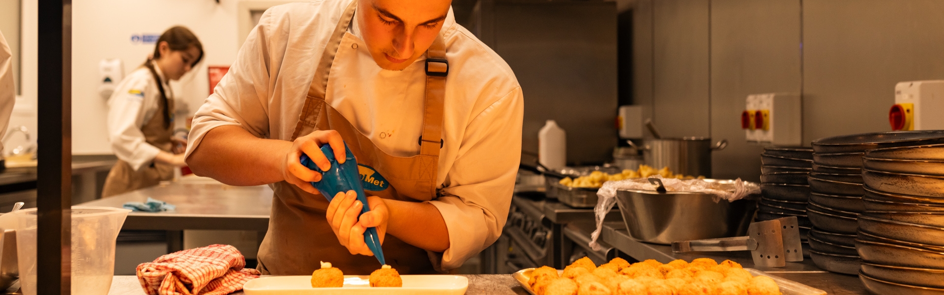 Culinary Arts student working inside of the Met At The Square restaurant inside of the Hamilton campus