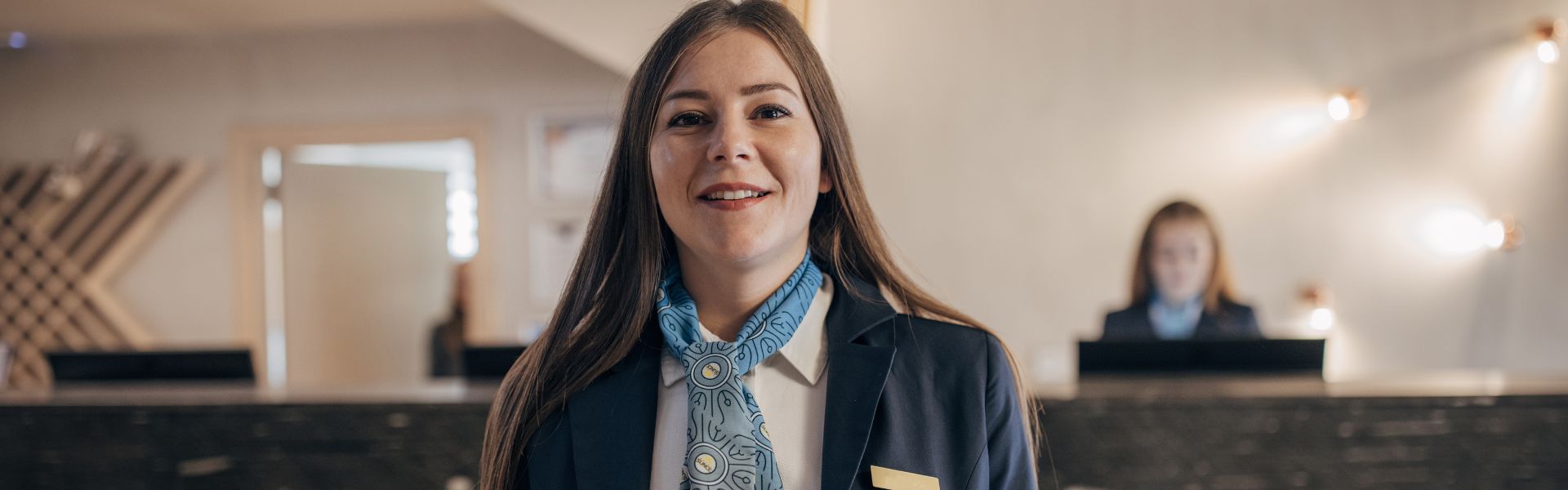 Supported intern stood in front of a hotel desk 