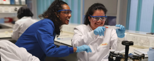 Two female students in a laboratory looking at a test tube