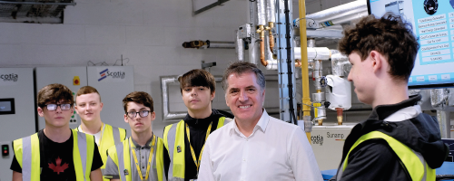 Metro Mayor Steve Rotheram standing next to Wirral Met Students wearing Hi-Vis Jackets